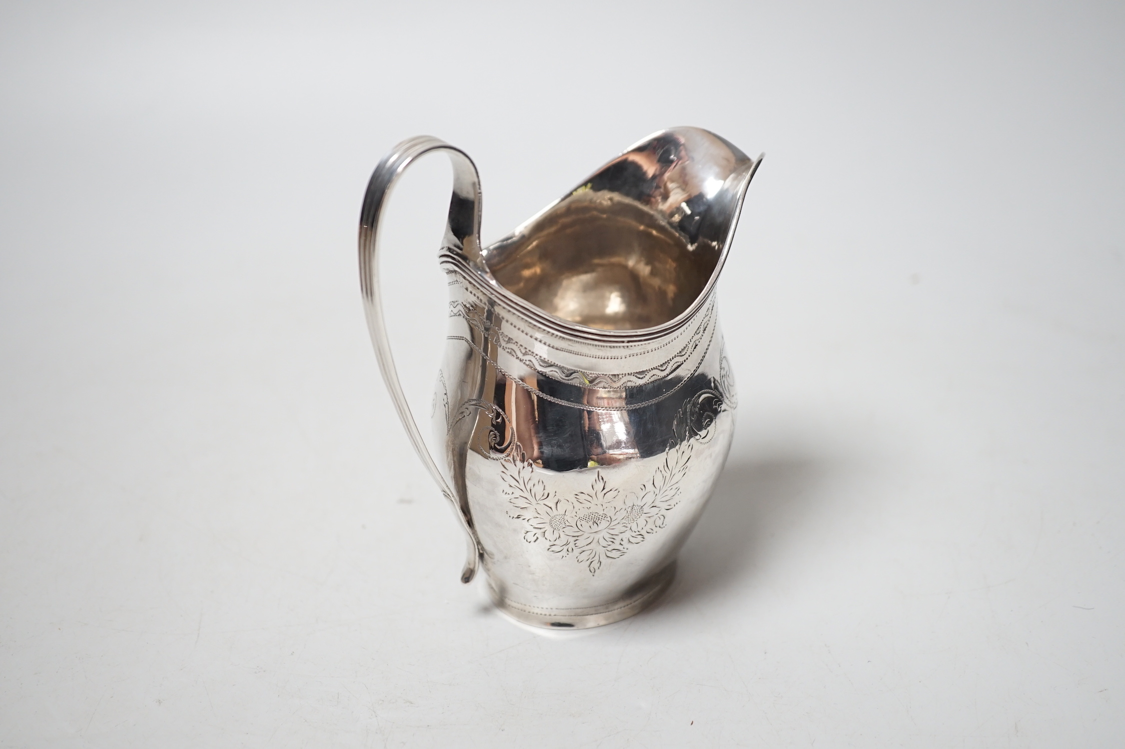 A George III engraved silver helmet shaped cream jug, Peter, Ann & William Bateman, London, 1802, 12.2cm, 108 grams.